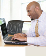Image of a businessman on his laptop doing a transaction.