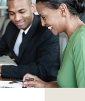 A business man and woman looking at financials at a boardroom table.